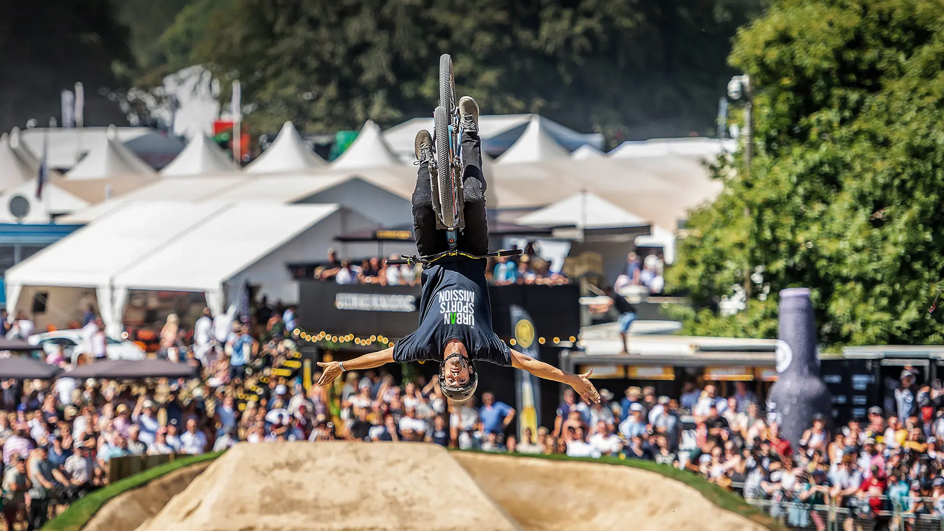 BMX rider performing a backflip at Goodwood Festival of Speed.